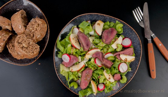 Het gerecht met gebakken ganzenborst met andijvie appelsalade